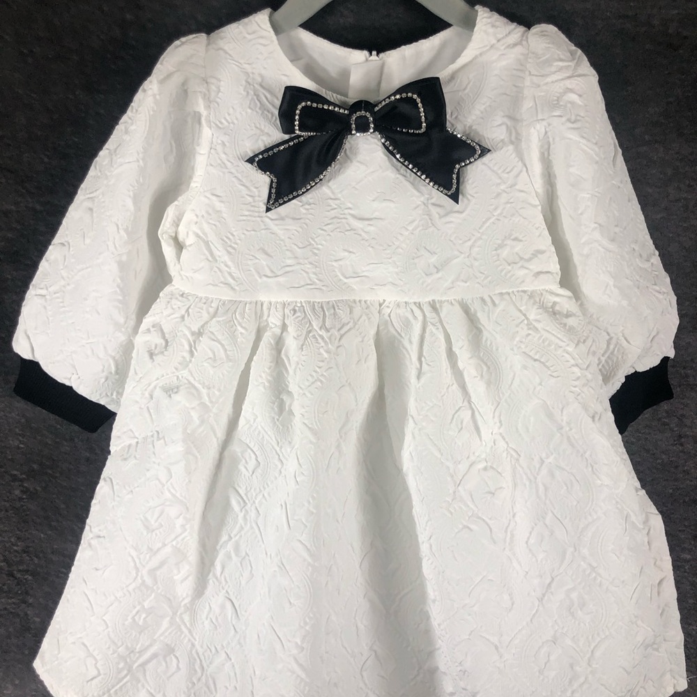 Girls/Toddler White textured dress with Black Bow Brooch.